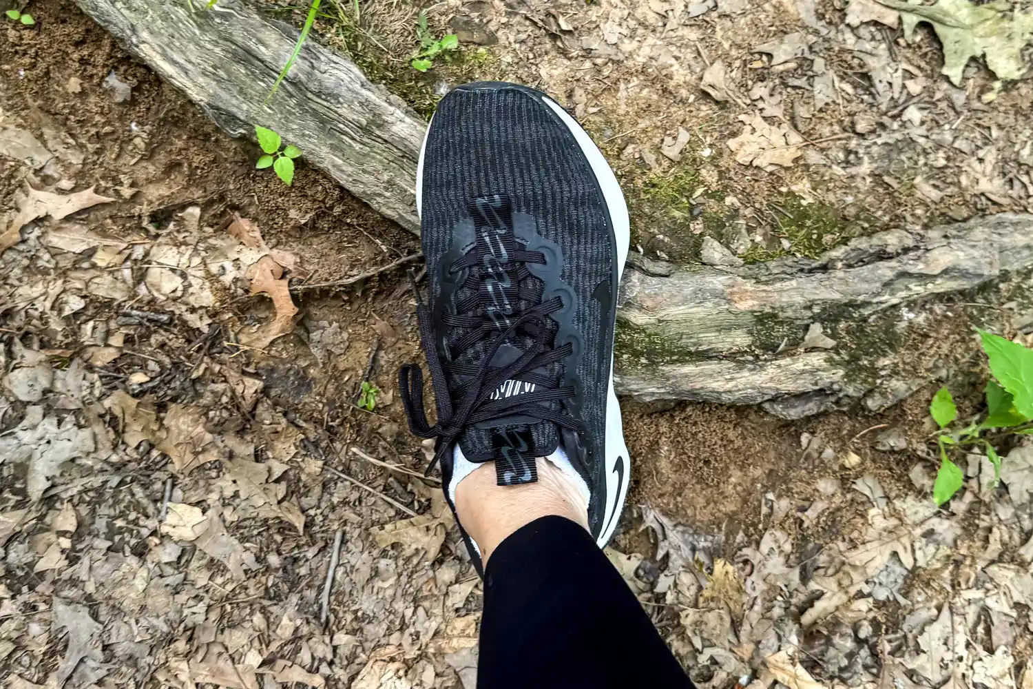 A person wears the Nike Motiva Women's Walking Shoes while hiking