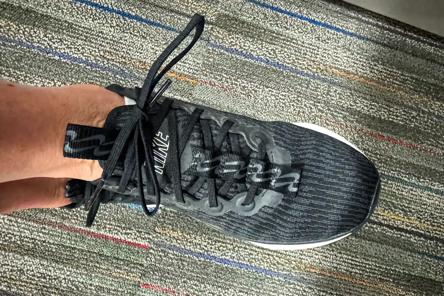 A person wears the Nike Motiva Women's Walking Shoe
