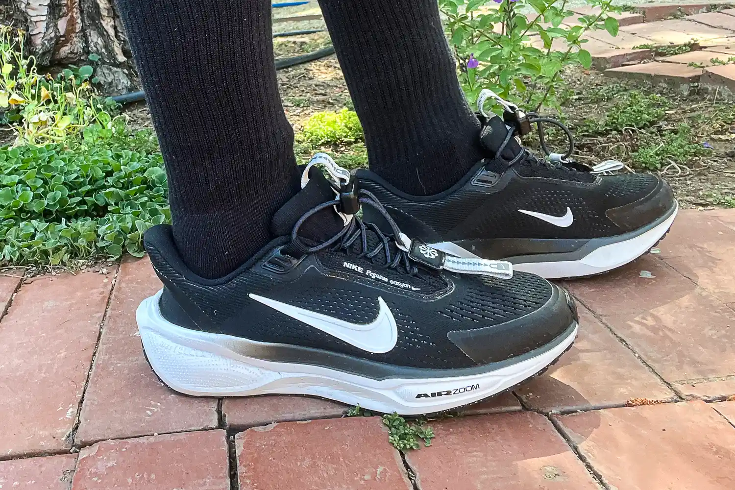 A person walks outside while wearing the Nike Pegasus EasyOn Women's Road Running Shoes