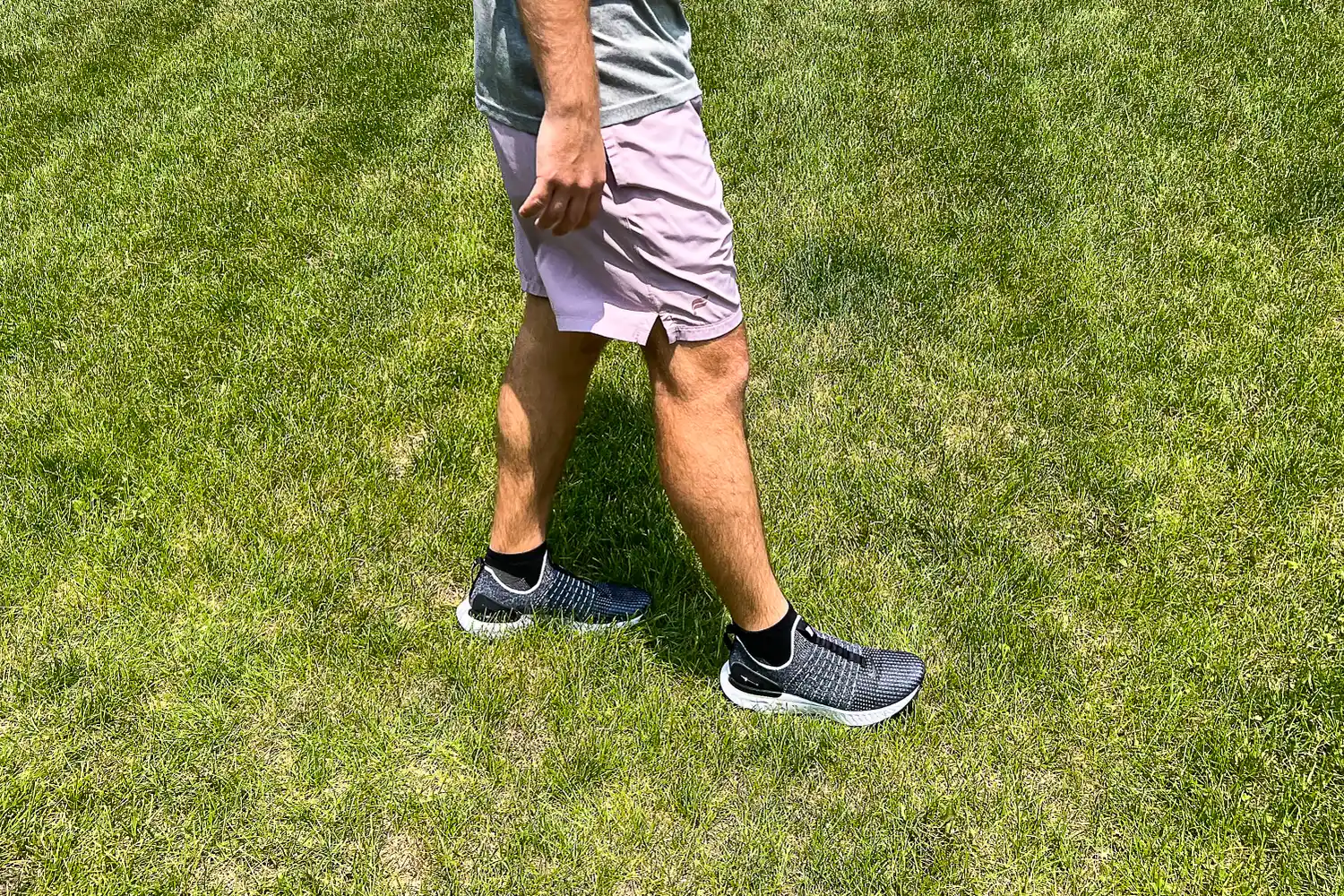 A person walks through grass while wearing the Nike React Phantom Run 2 Men's Road Running Shoes