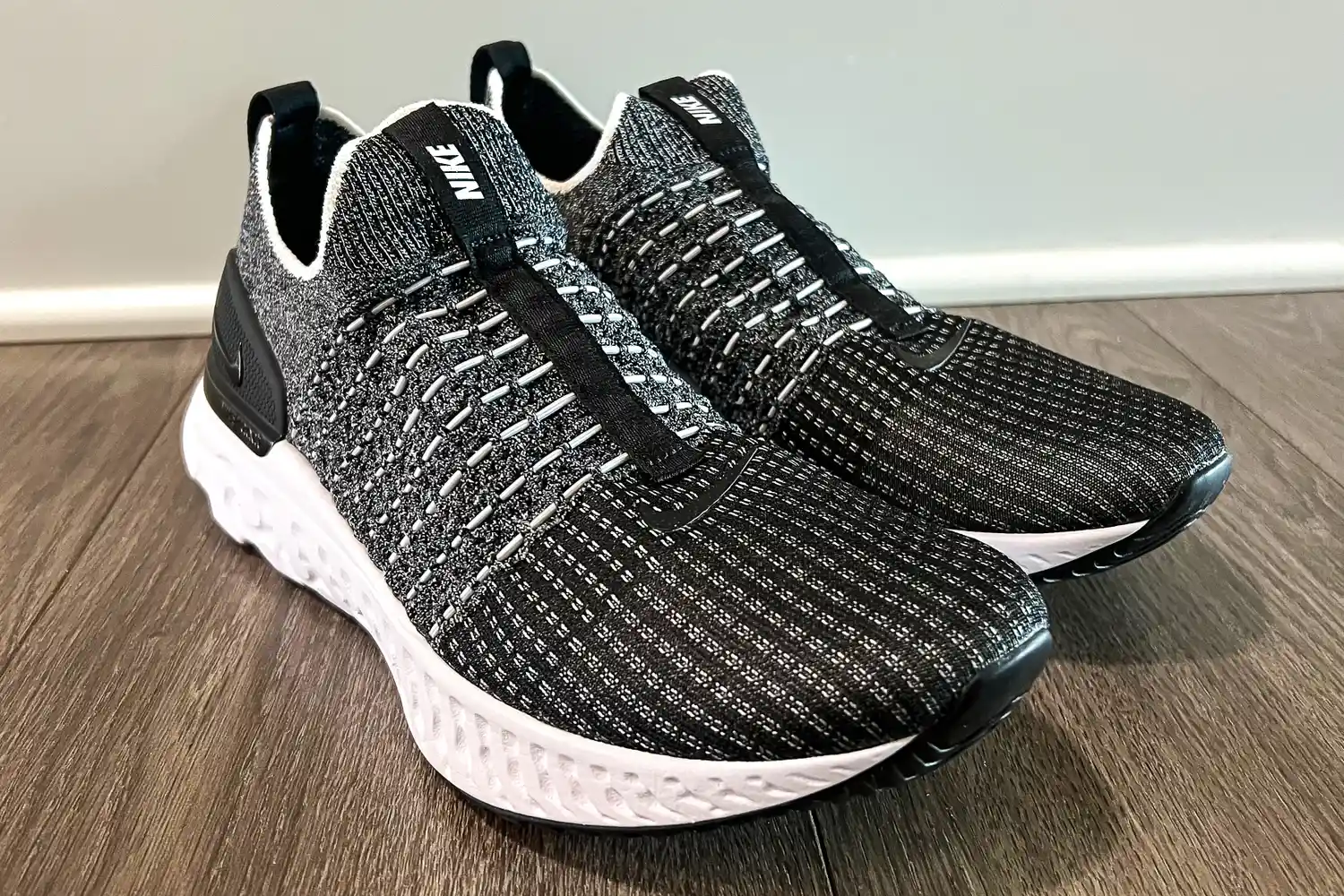 A pair of Nike React Phantom Run 2 Men's Road Running Shoes on a wooden floor