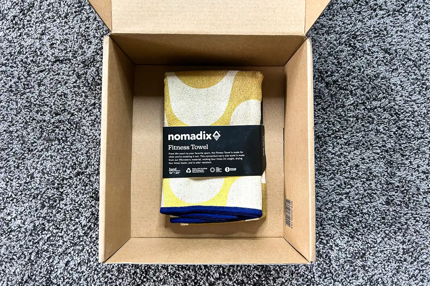 The Nomadix Fitness Towel folded in a shipping box