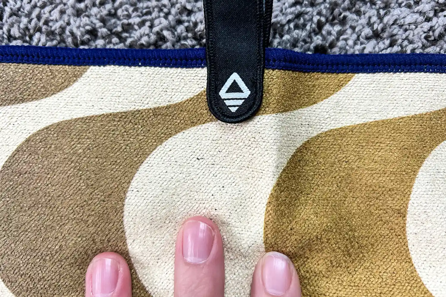 A person touches the fabric on the Nomadix Fitness Towel
