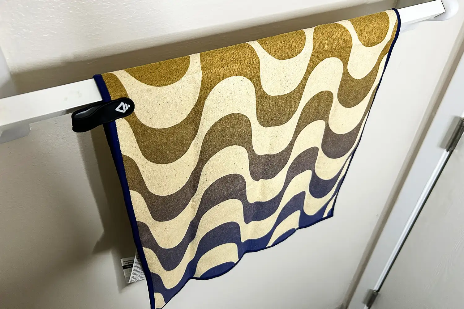 The Nomadix Fitness Towel hangs from a towel rack