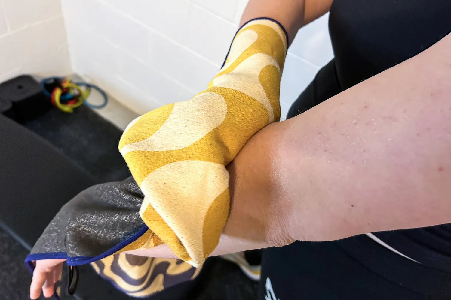 A person wipes their arm using the Nomadix Fitness Towel