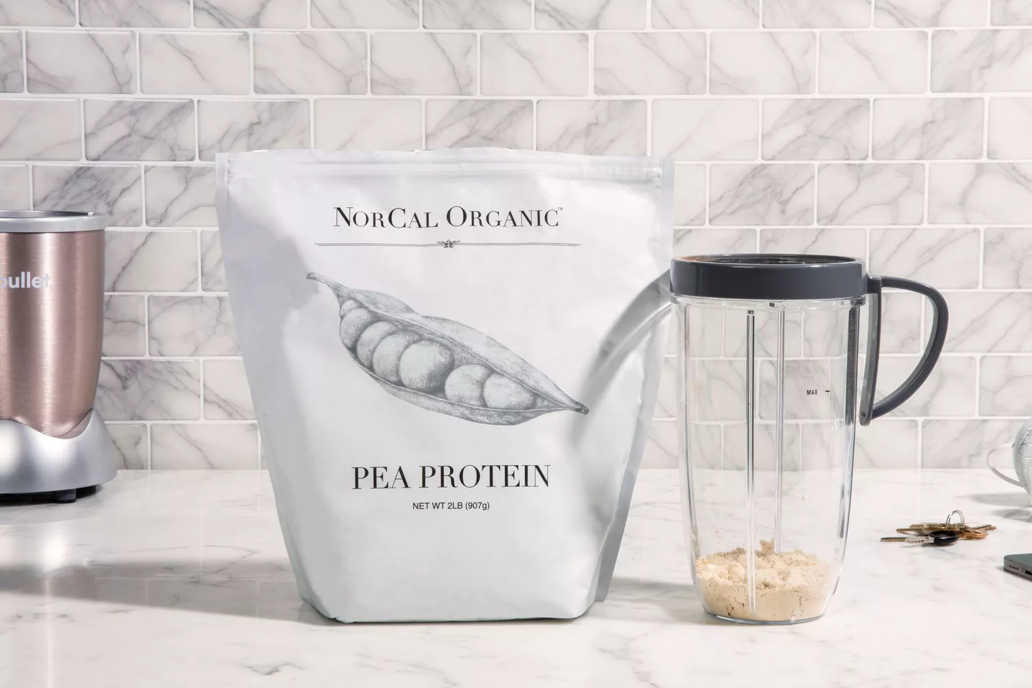 NorCal Organic Premium Pea Protein on marble counter next to cup filled with protein