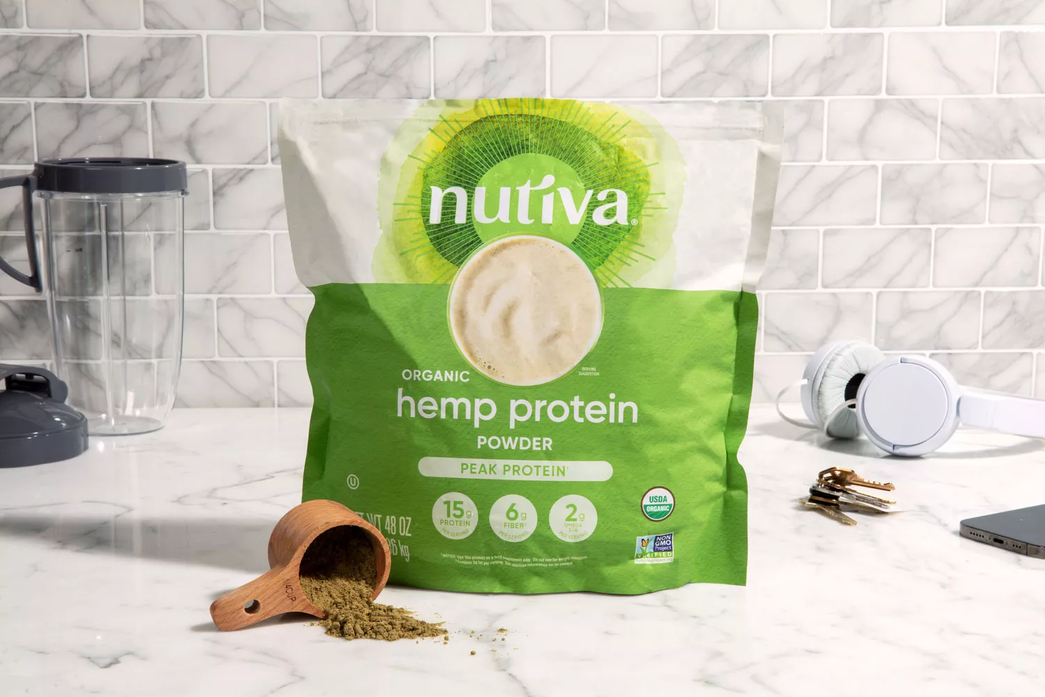 Nutiva Hemp Seed Protein Powder on marble counter next to scoop of protein powder