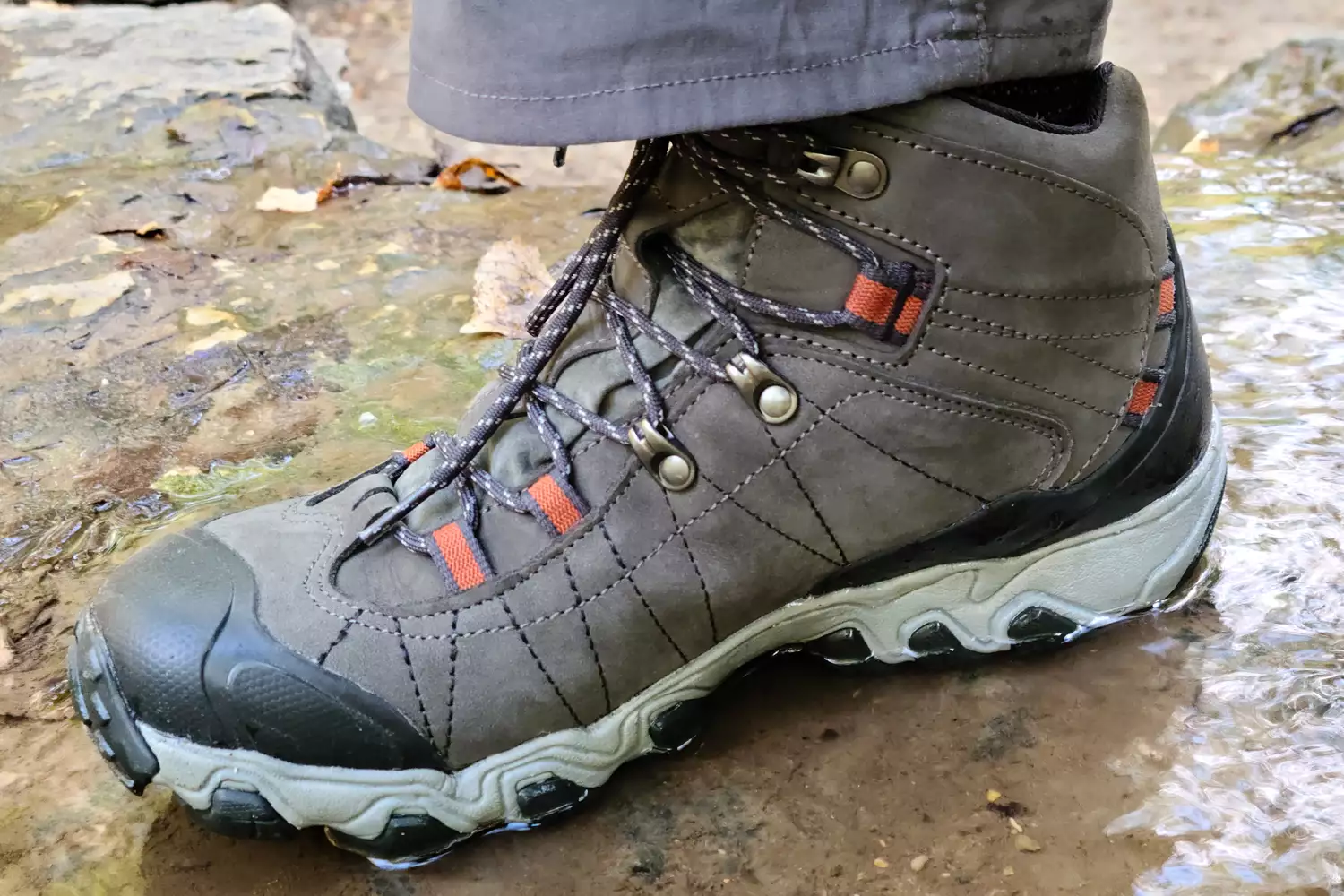 Foot on muddy ground wearing Oboz Bridger 9 Inch Insulated Waterproof Hiking Boot