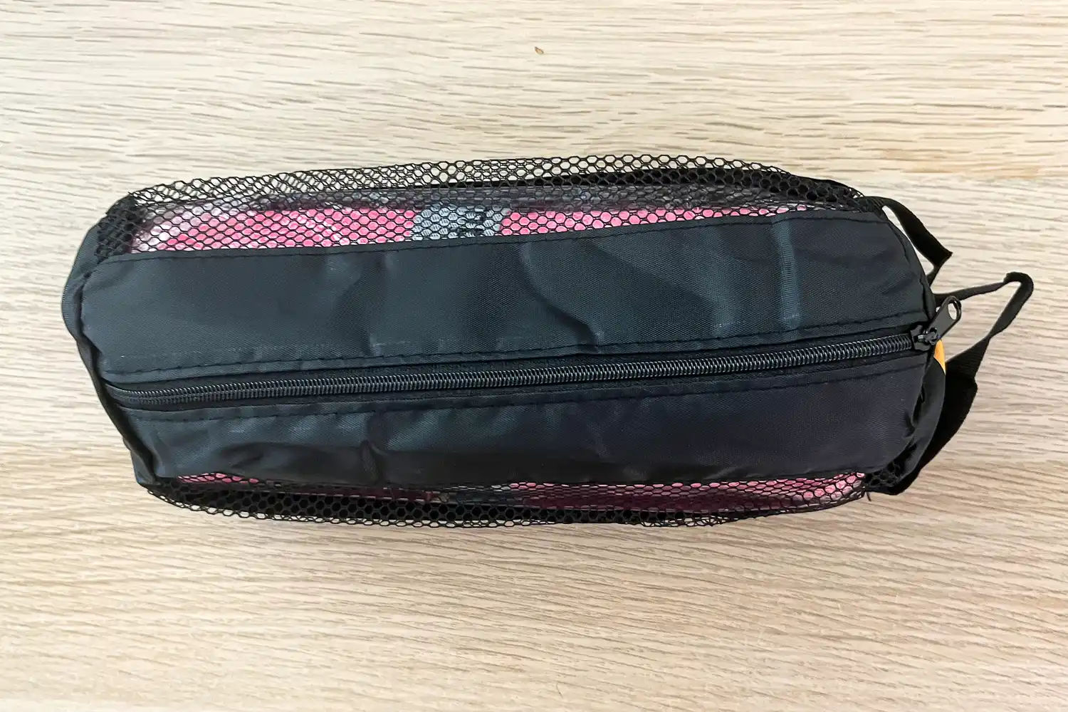 The OlimpiaFit Quick Dry Towel inside a mesh storage bag