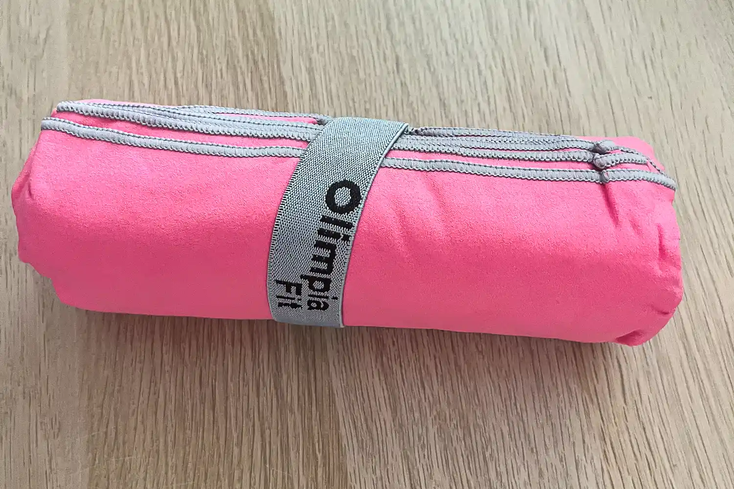 The OlimpiaFit Quick Dry Towels rolled up and secured with a strap