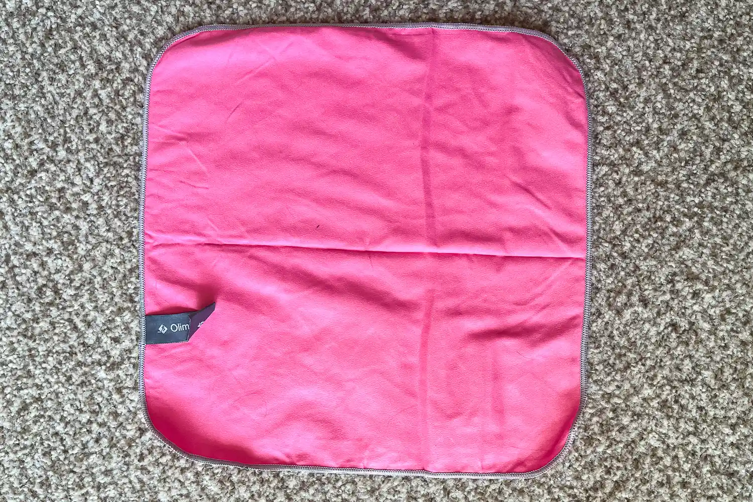 The OlimpiaFit Quick Dry Towel folded on carpet