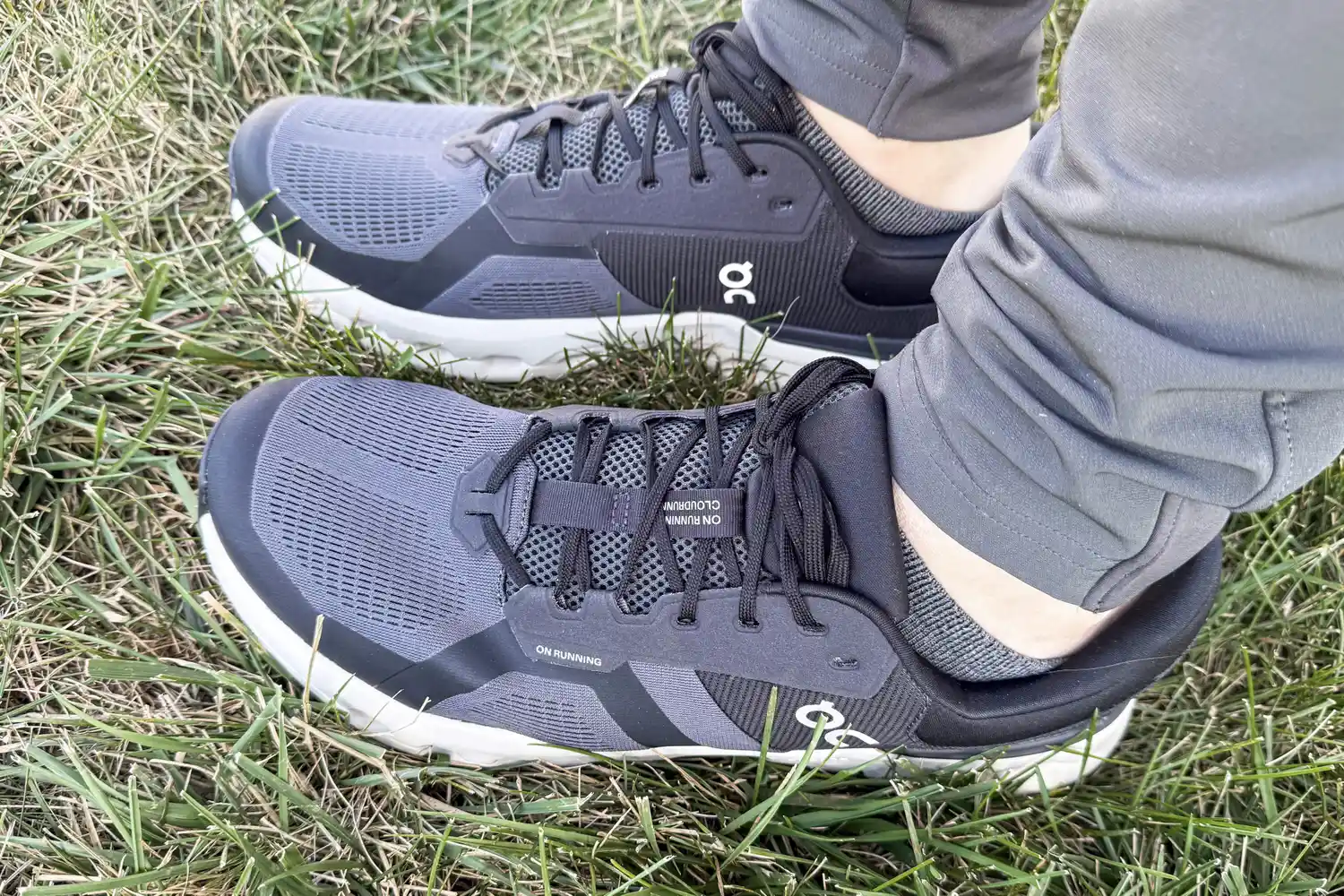 A person wears the On Running Men's Cloudrunner 2 Wide Running Shoes in grass