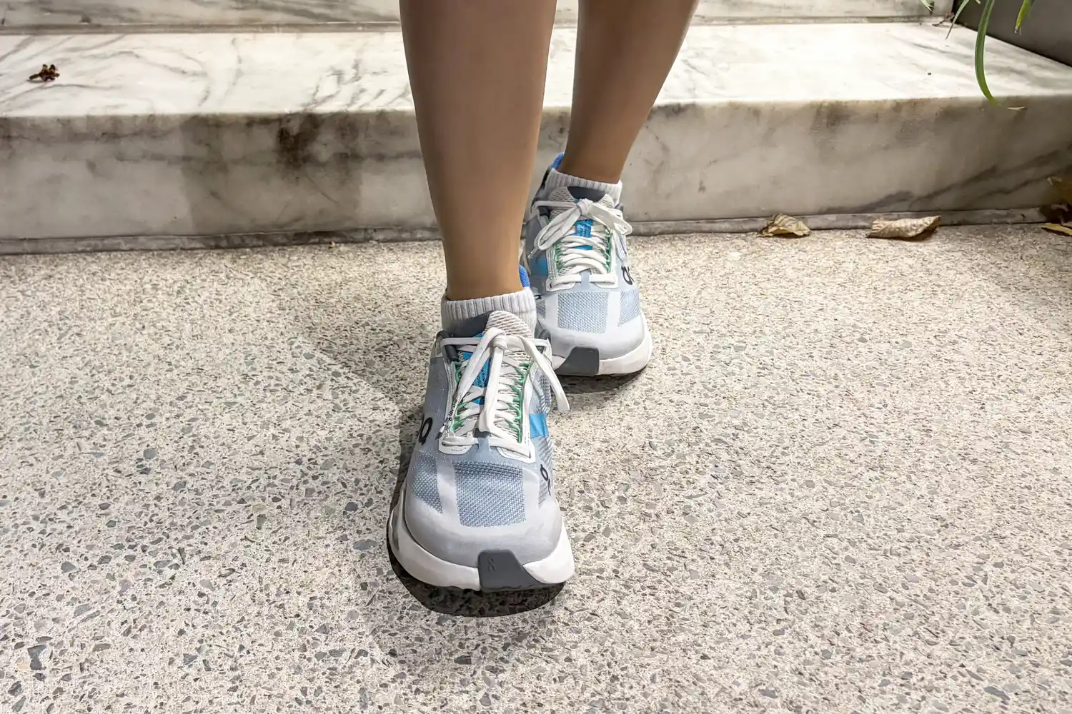 A person wears the On Running Women's Cloudsurfer Next Wide Running Shoes while walking