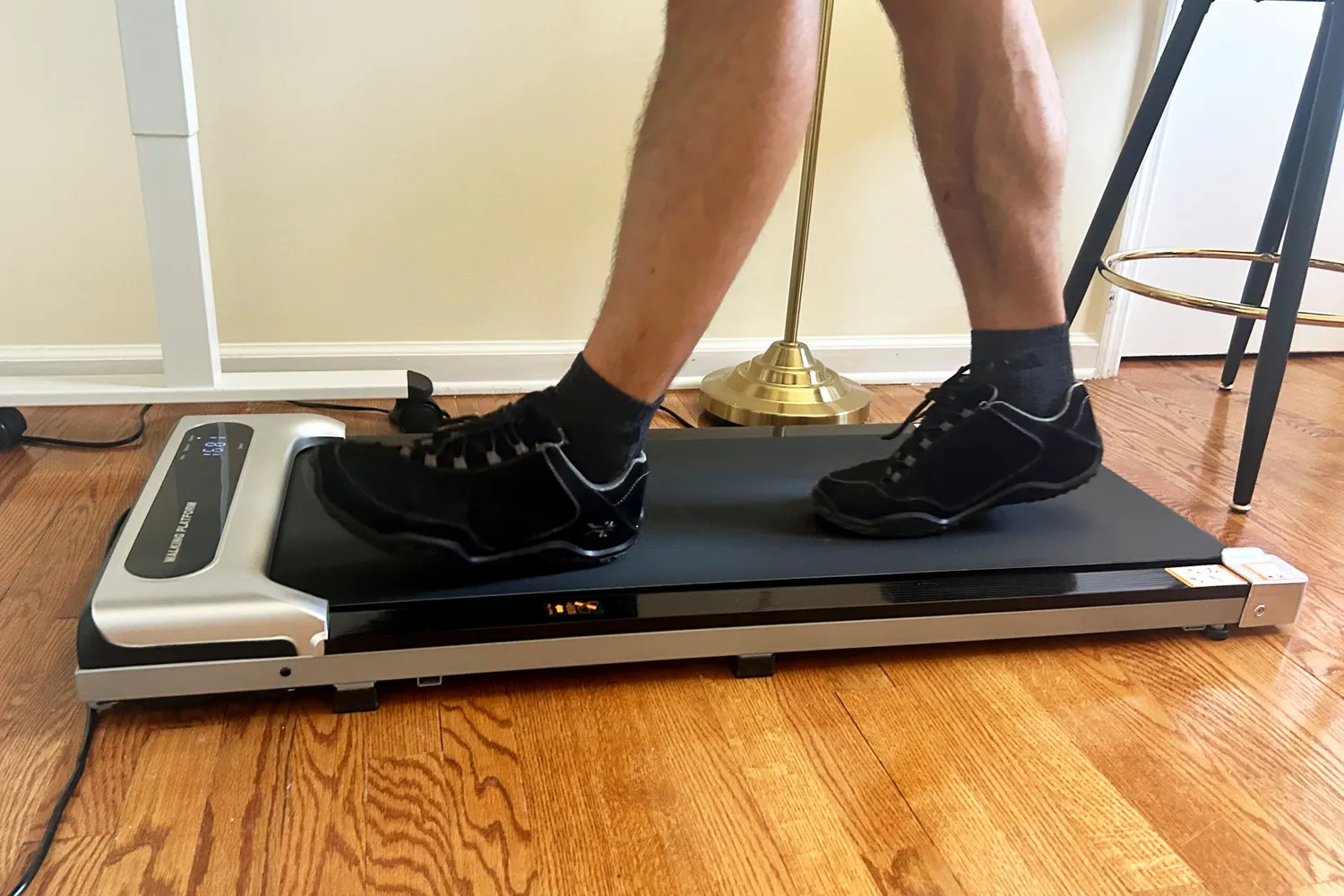 A side view of a person walking on the Orinar 3-in-1 Walking Pad