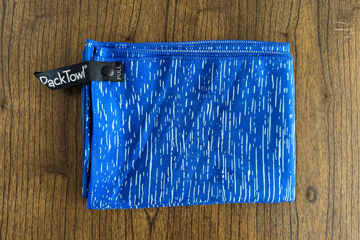 The PackTowl Personal Quick Dry Microfiber Towel folded on a table