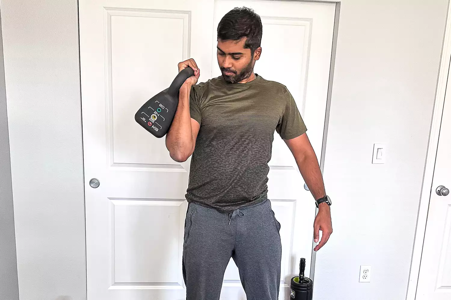 A person holds up the PowerBlock Adjustable Kettlebell Weight