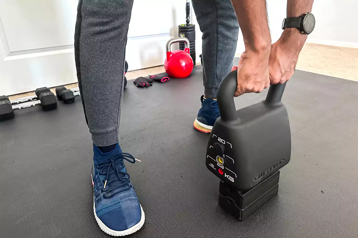 A person adjusts the weights of the PowerBlock Adjustable Kettlebell Weight 