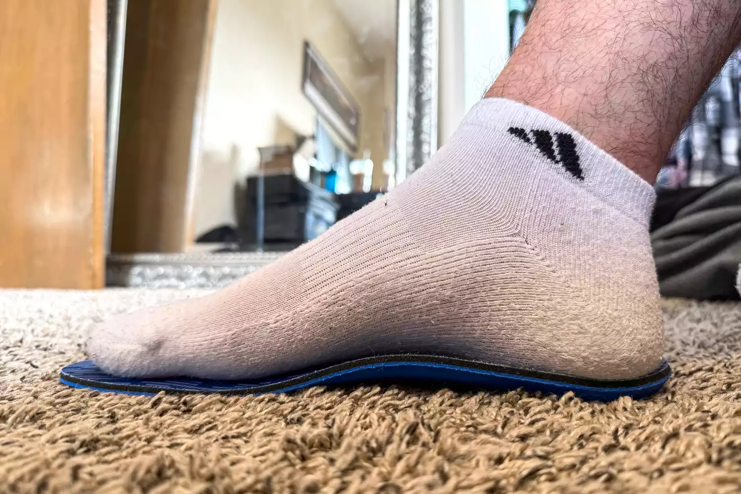 A person with their foot placed on top of the PowerStep Pinnacle Low Insole