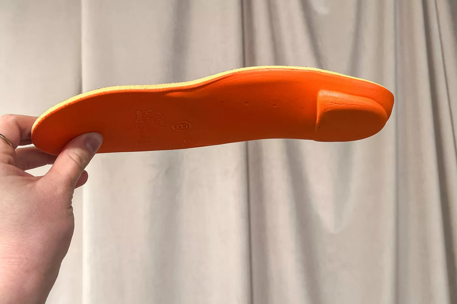 A person holds up the PowerStep PULSE Maxx Insole