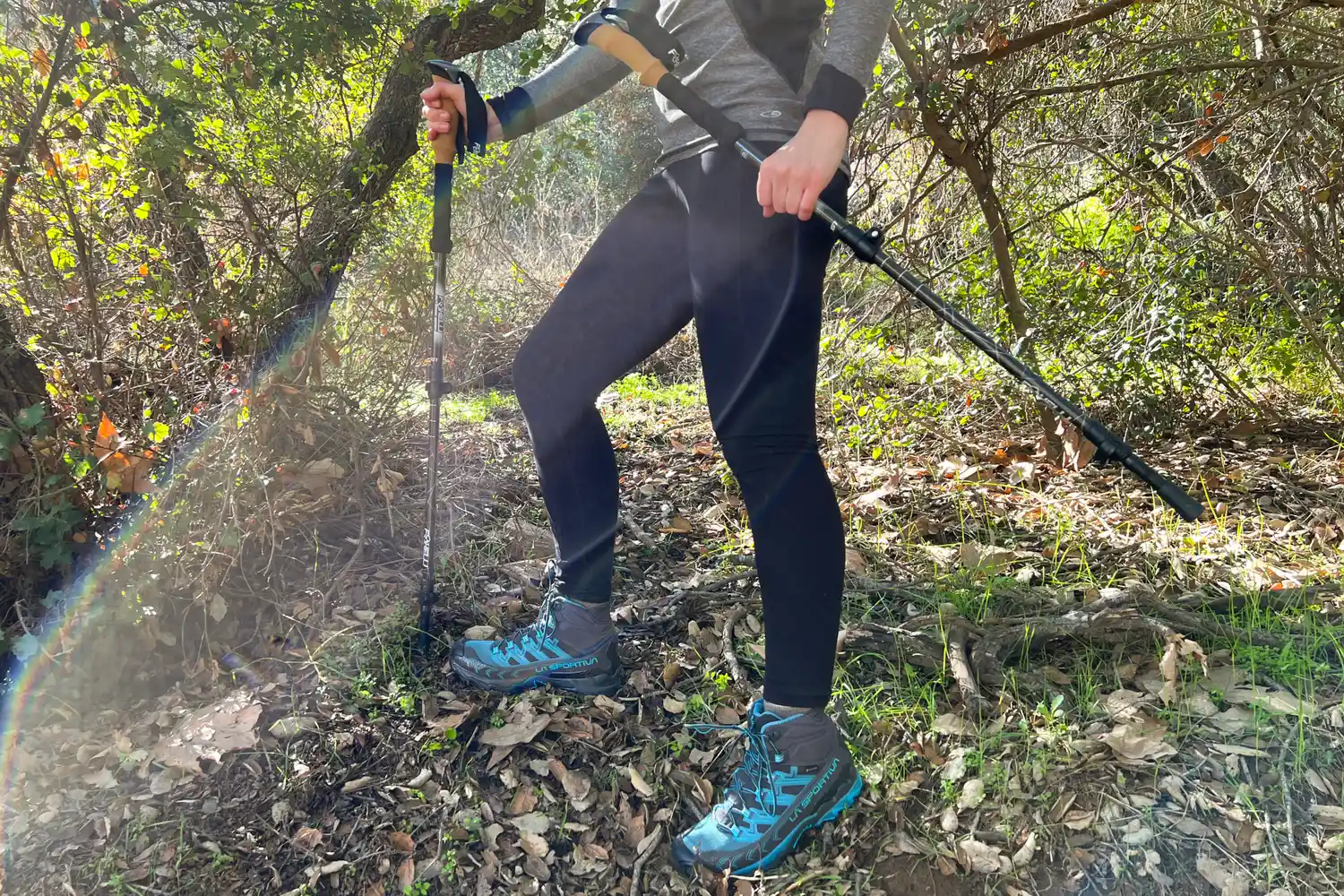 Person walking in woods with Foxelli Carbon Fiber Trekking Poles