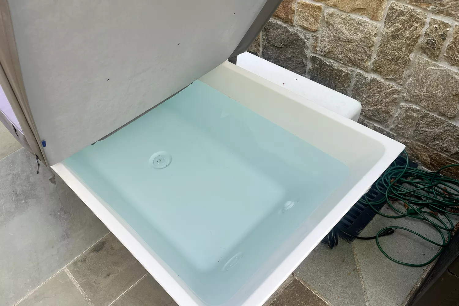 The cover being lifted off the PLUNGE cold tub