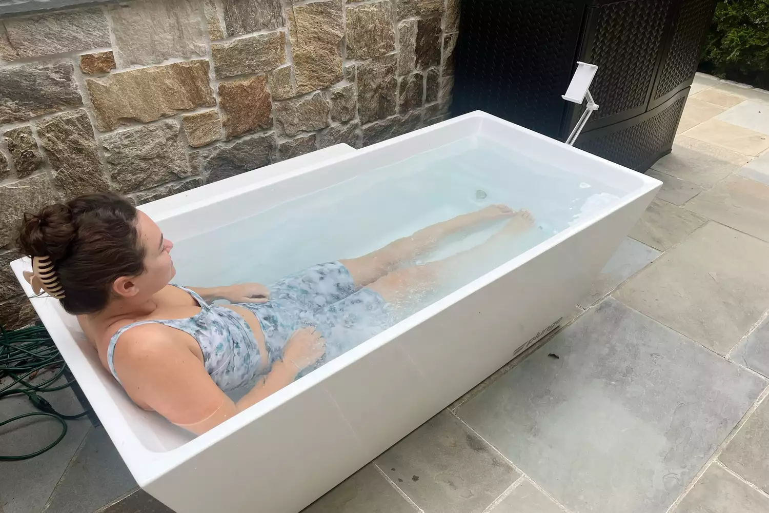 A person sitting in the PLUNGE cold tub