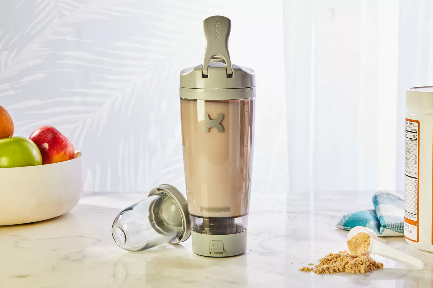 PROMiXX Pro Shaker Rechargeable Bottle displayed on counter with protein powder and fruit