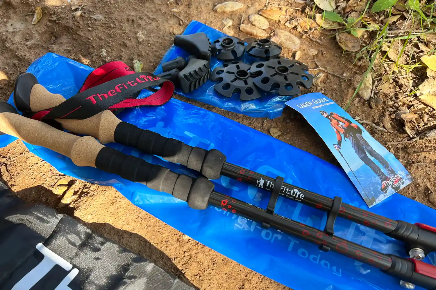 Hiking poles with accessories user guide and storage items on the ground outdoors