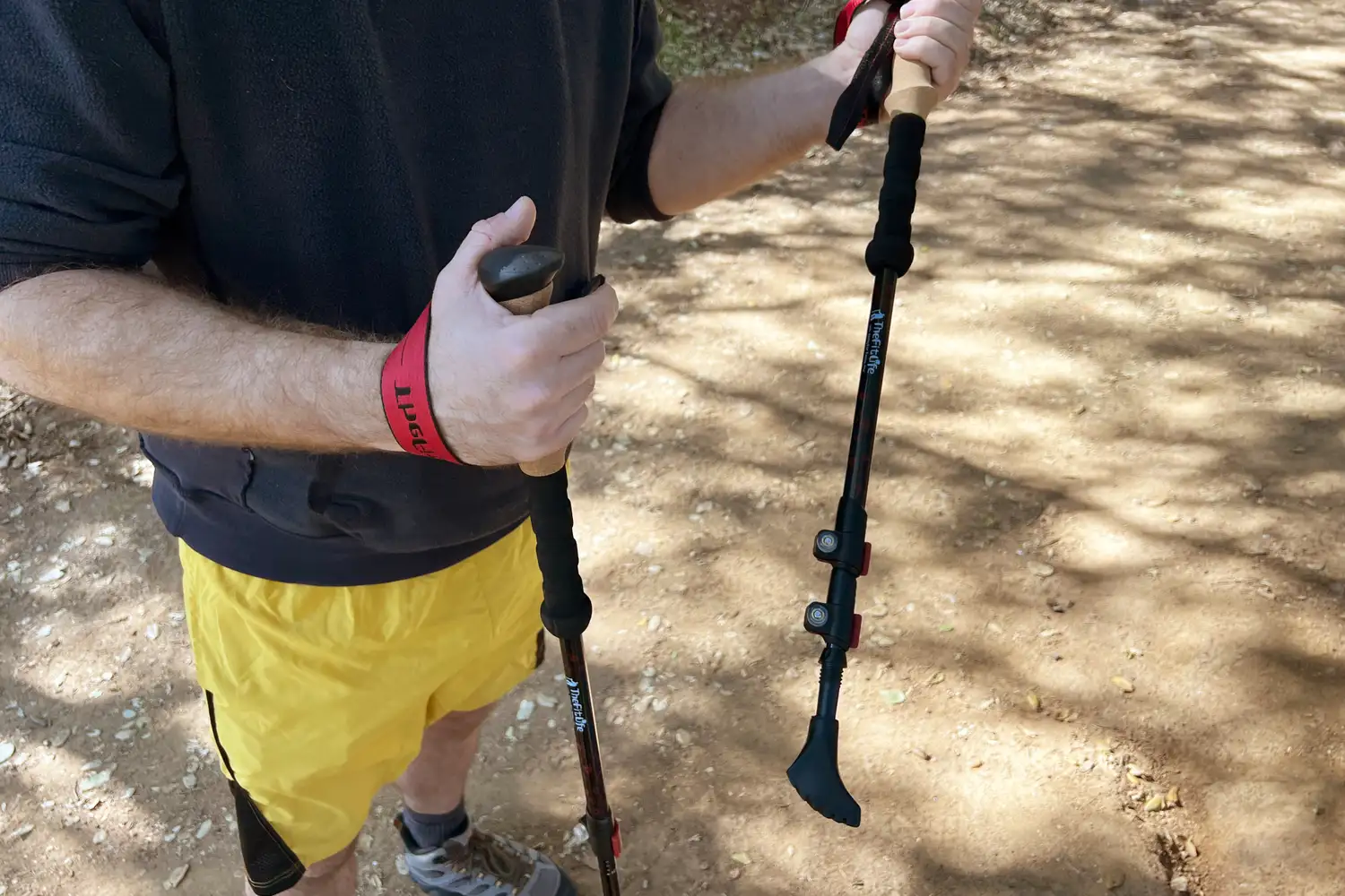 Person holding trekking poles on a trail wearing activewear