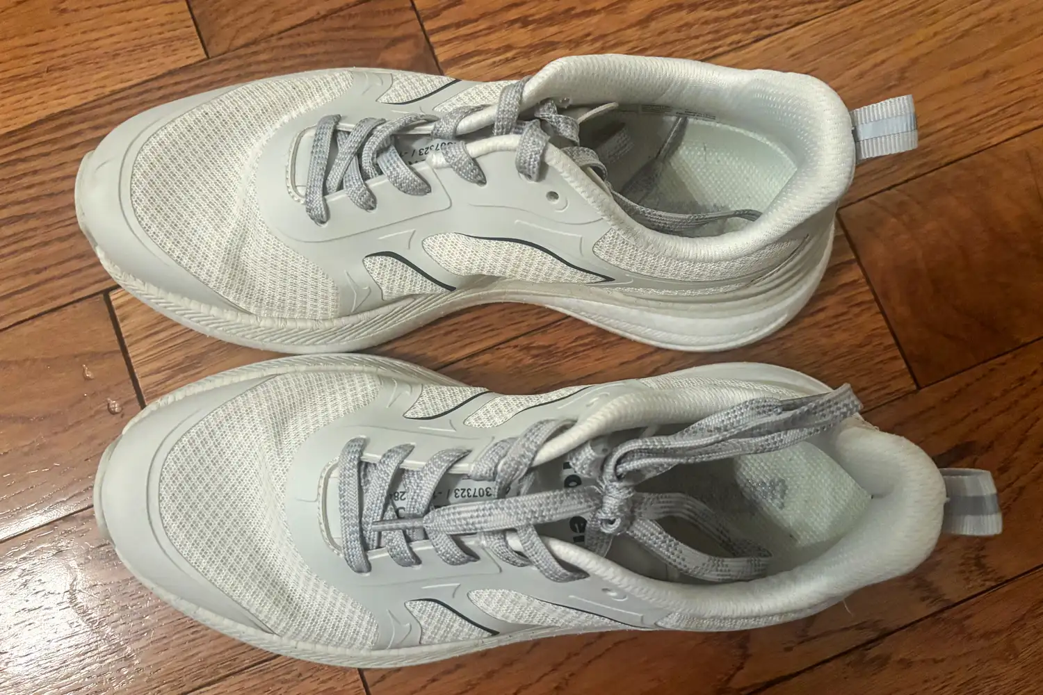 A pair of Propét DuroCloud 392 Women's Sneakers with laces on a wooden floor