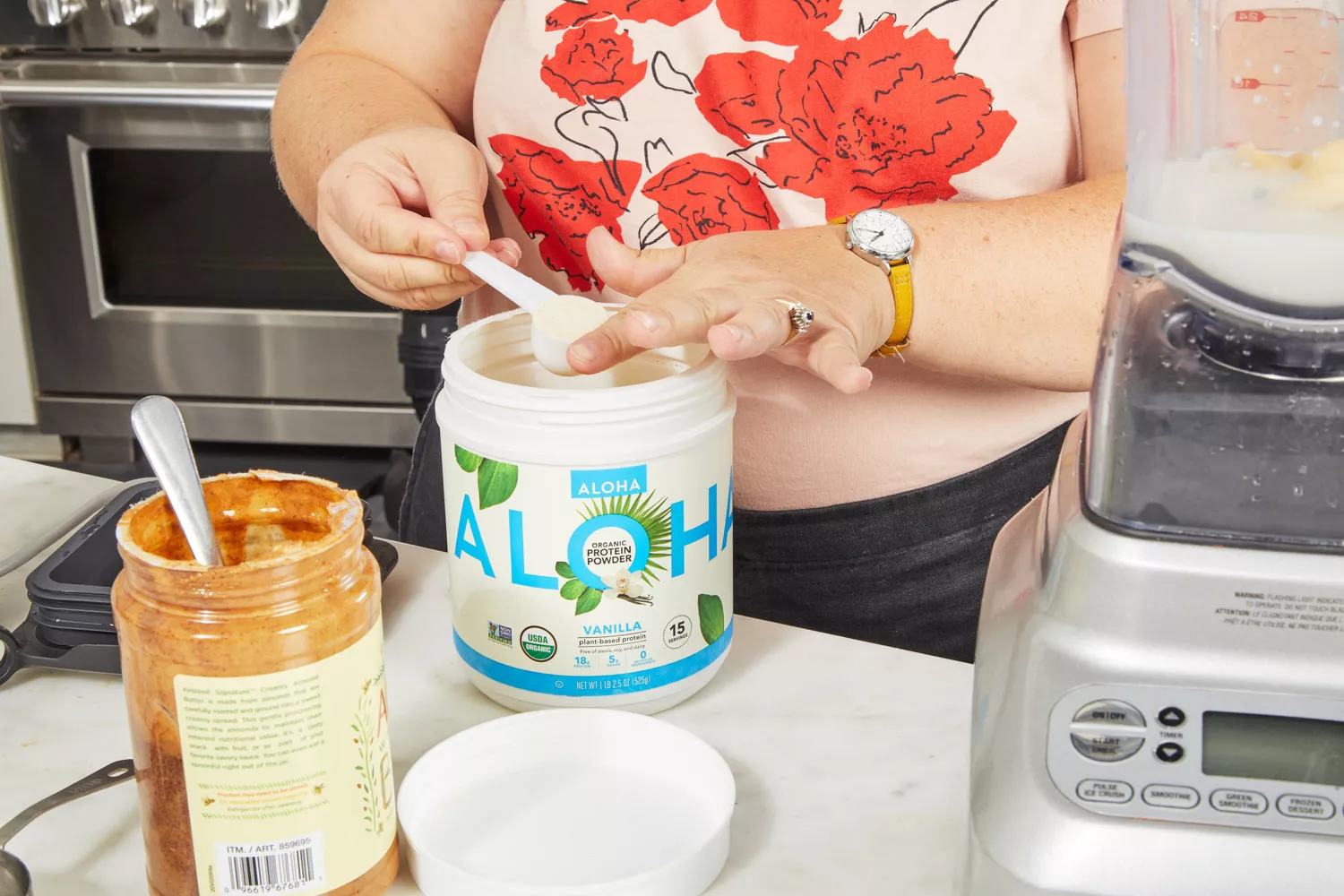 Person scooping powder from Aloha Vanilla Organic Plant Based Protein Powder