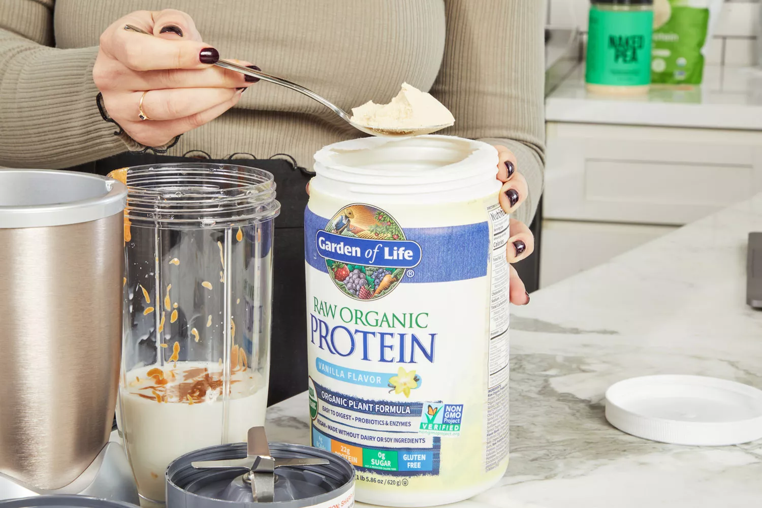 Person scooping powder from Garden of Life Raw Organic Vanilla Protein Powder