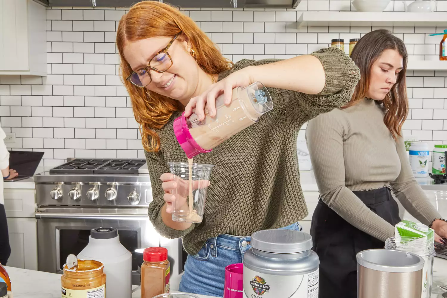 pouring Garden of Life Sport Organic Plant-Based Protein Powder into cup 