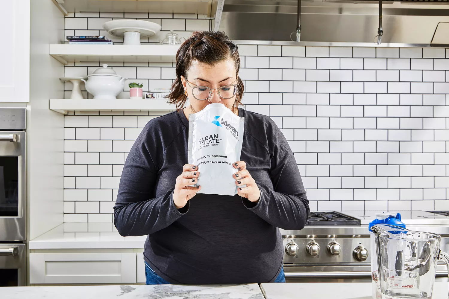 A person smells the Klean Athlete Klean Isolate Protein Powder