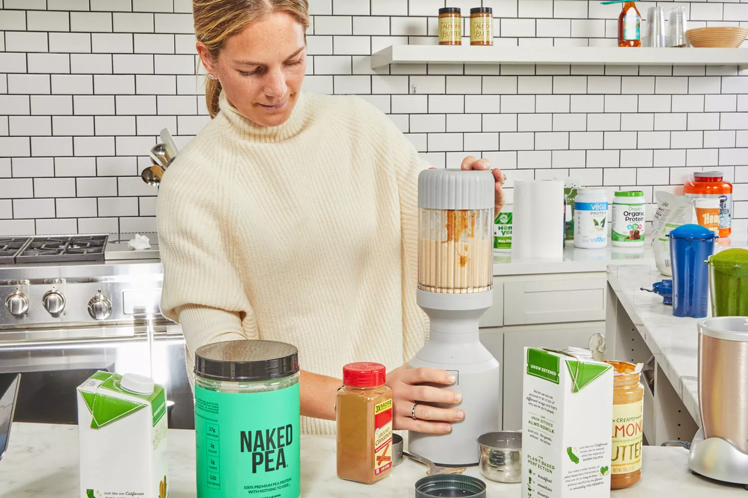 Person mixing drink next to NAKED nutrition NAKED PEA 1LB Pea Protein Isolate