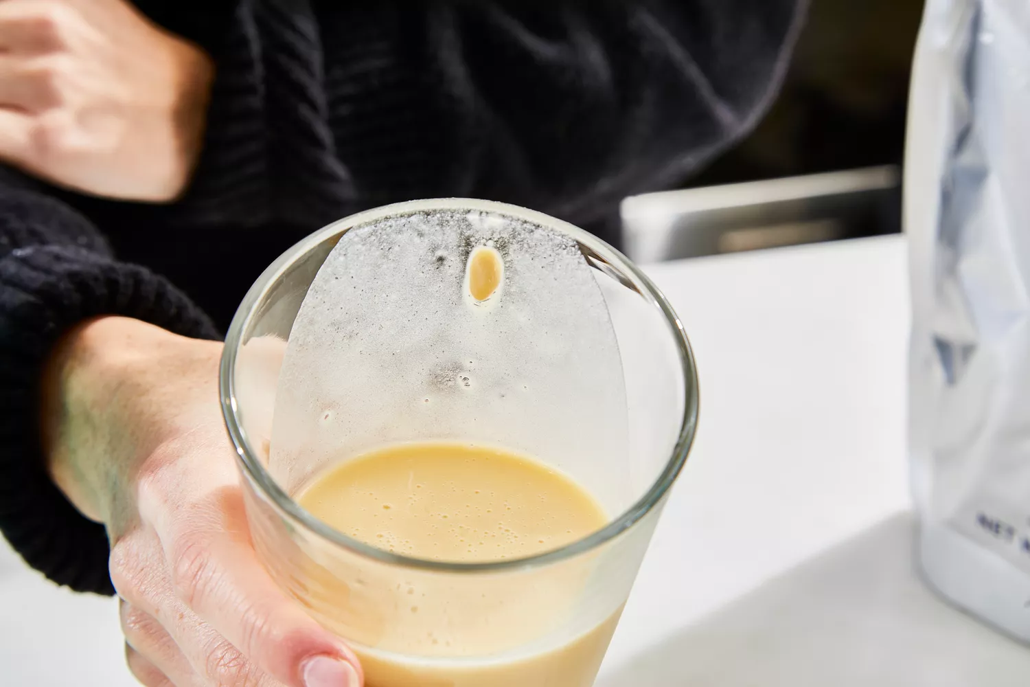 A glass of Ritual Essential Protein Daily Shake Protein Powder