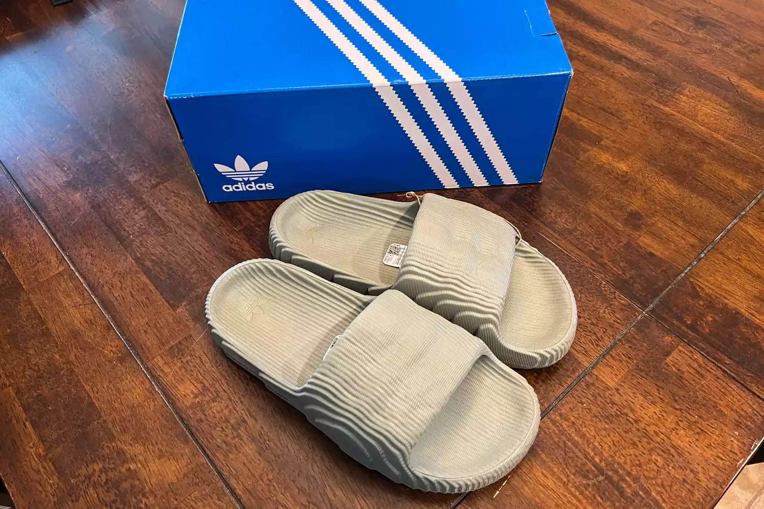 An overhead view of a pair of Adidas Adilette 22 Slides next to a shoebox
