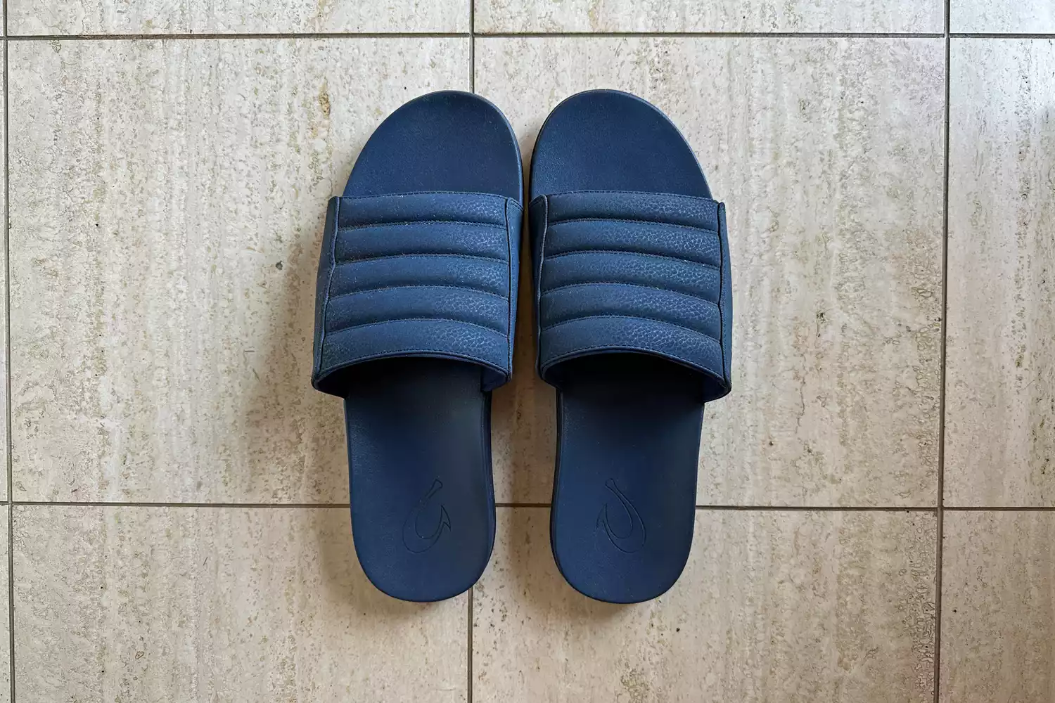 An overhead view of a pair of OluKai MahaâOlu Menâs Slide Sandals