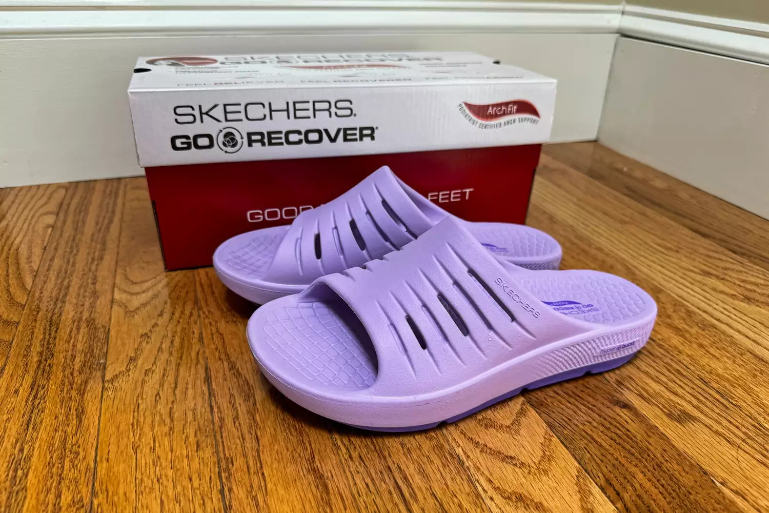 A pair of Skechers Women's GO RECOVER Refresh Slides next to a shoebox