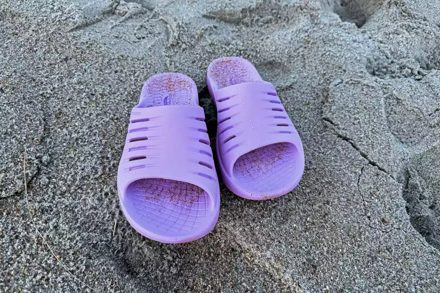 A pair of purple Skechers Women's GO RECOVER Refresh Slides in sand