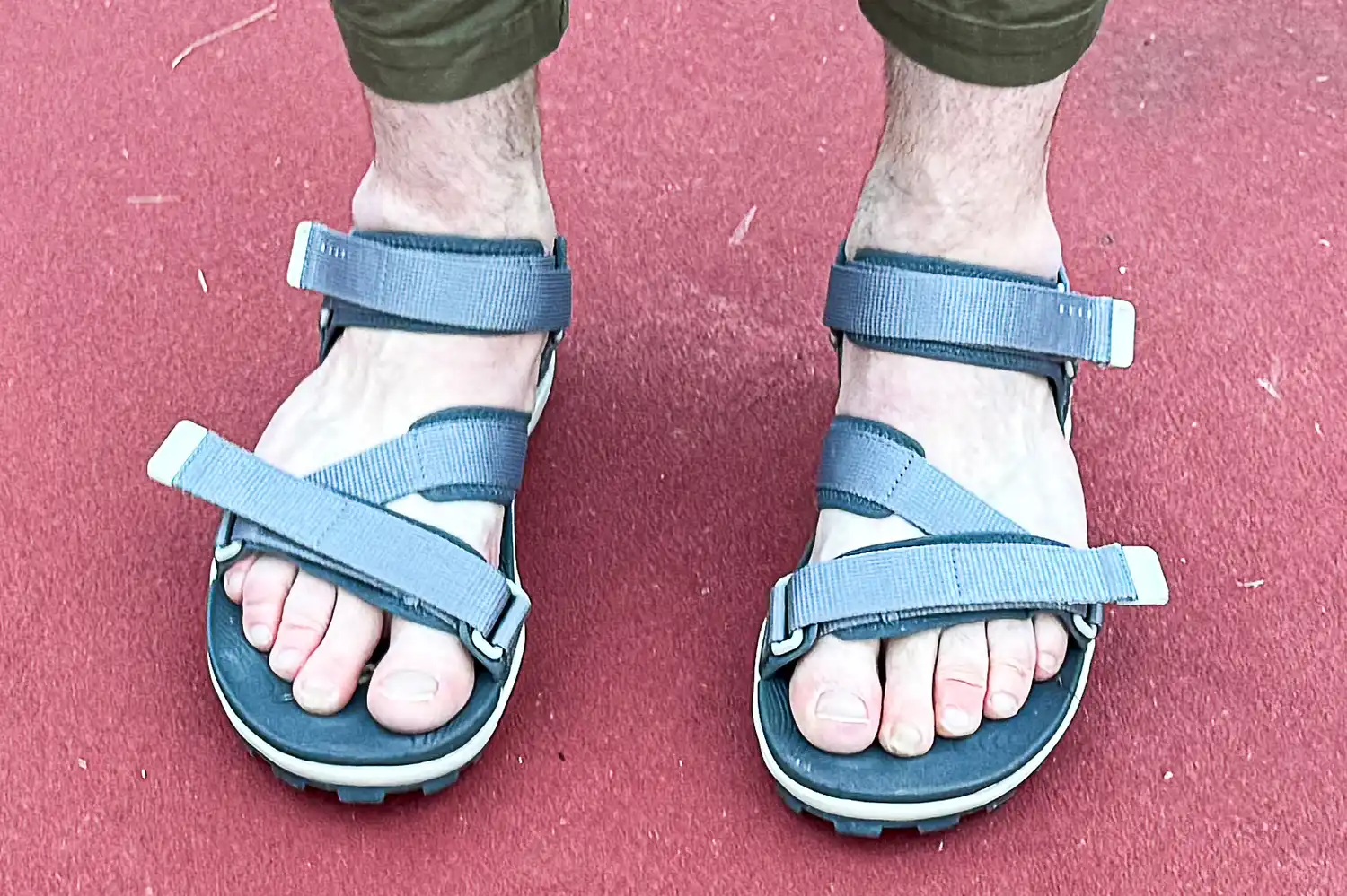 A person wears the Reef Men's Cross-Shore Sandals outside