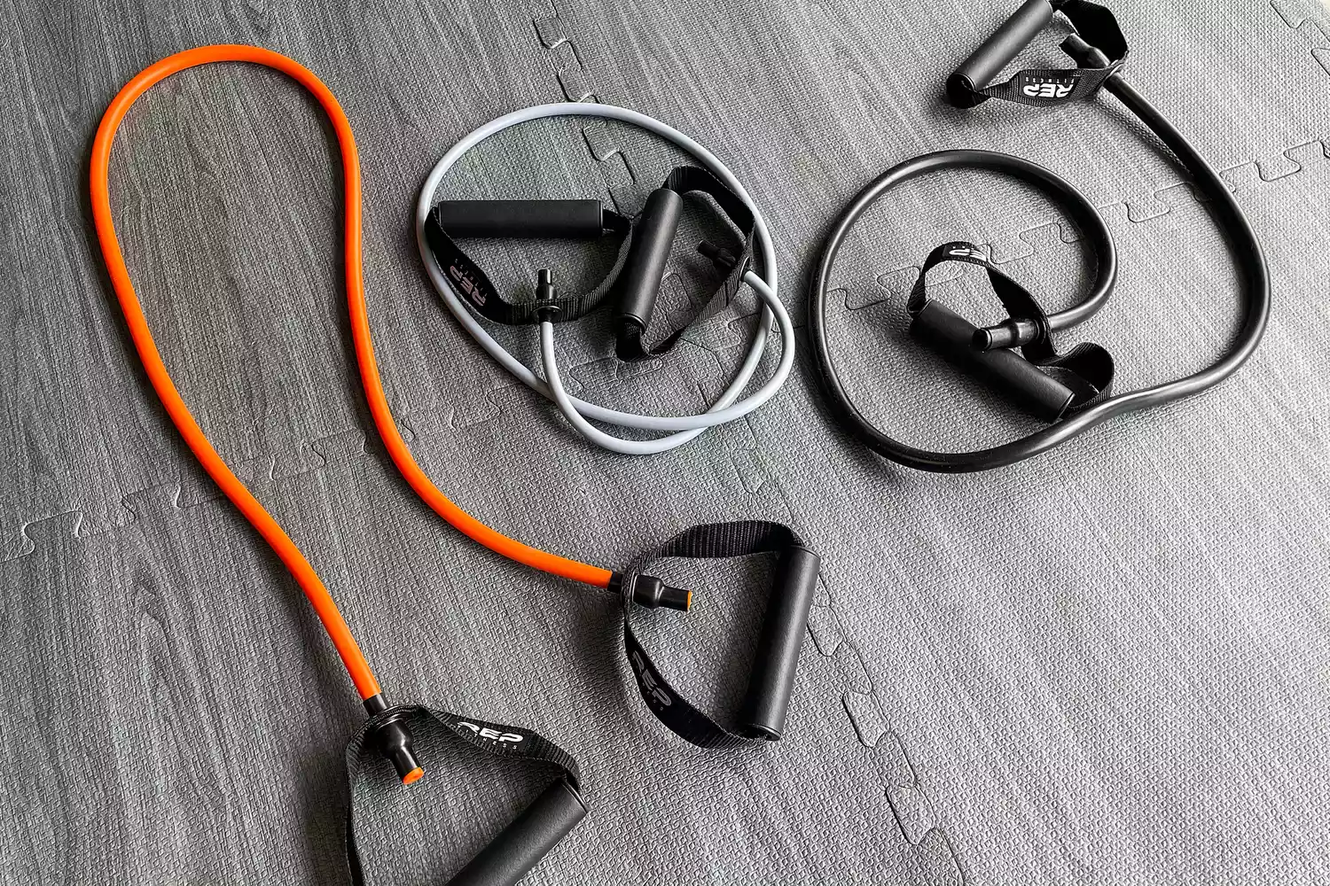 Three Rep Fitness Tube Resistance Bands with Handles on a gray floor