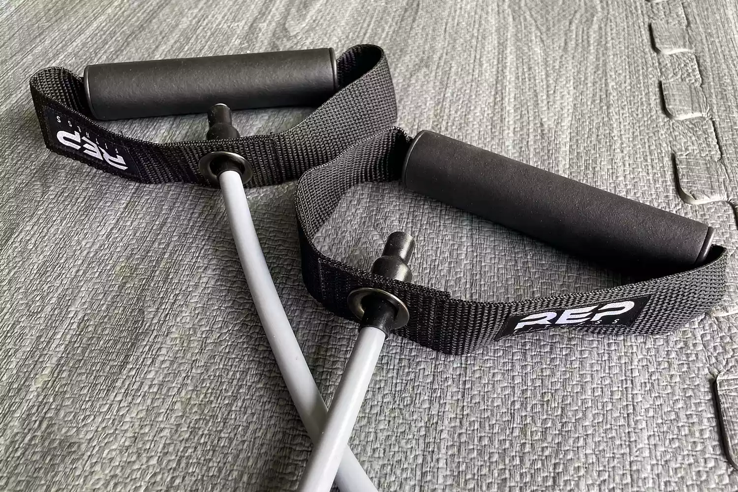 A close-up of the handles on the Rep Fitness Tube Resistance Bands on a gray background
