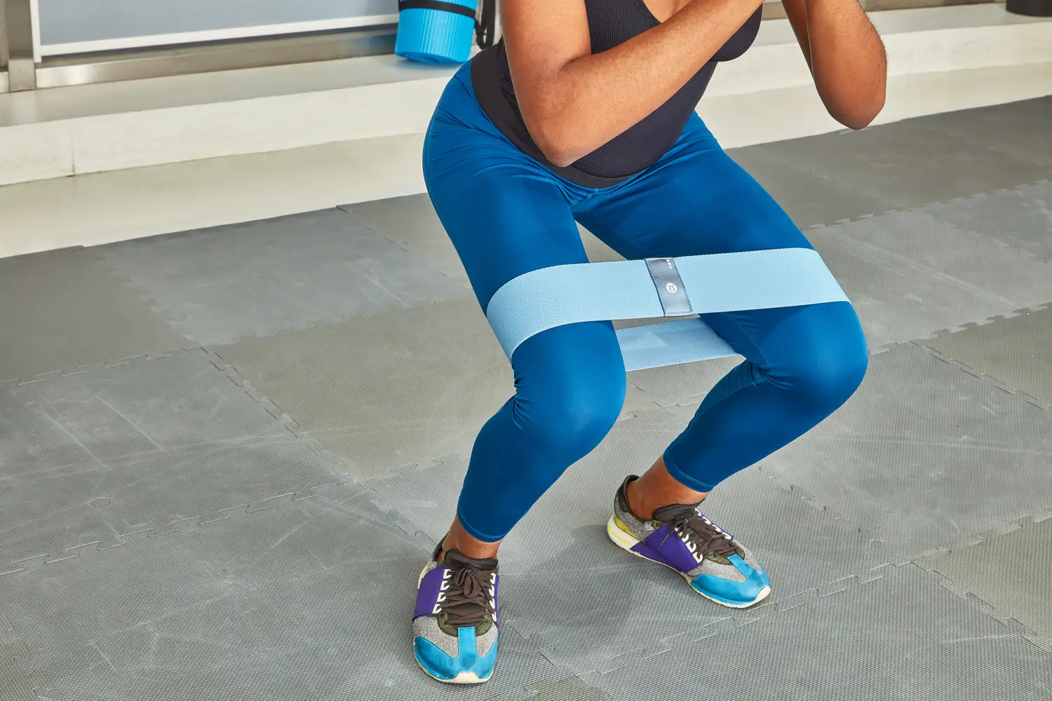 A person squats using the Lululemon Resistance Band Set