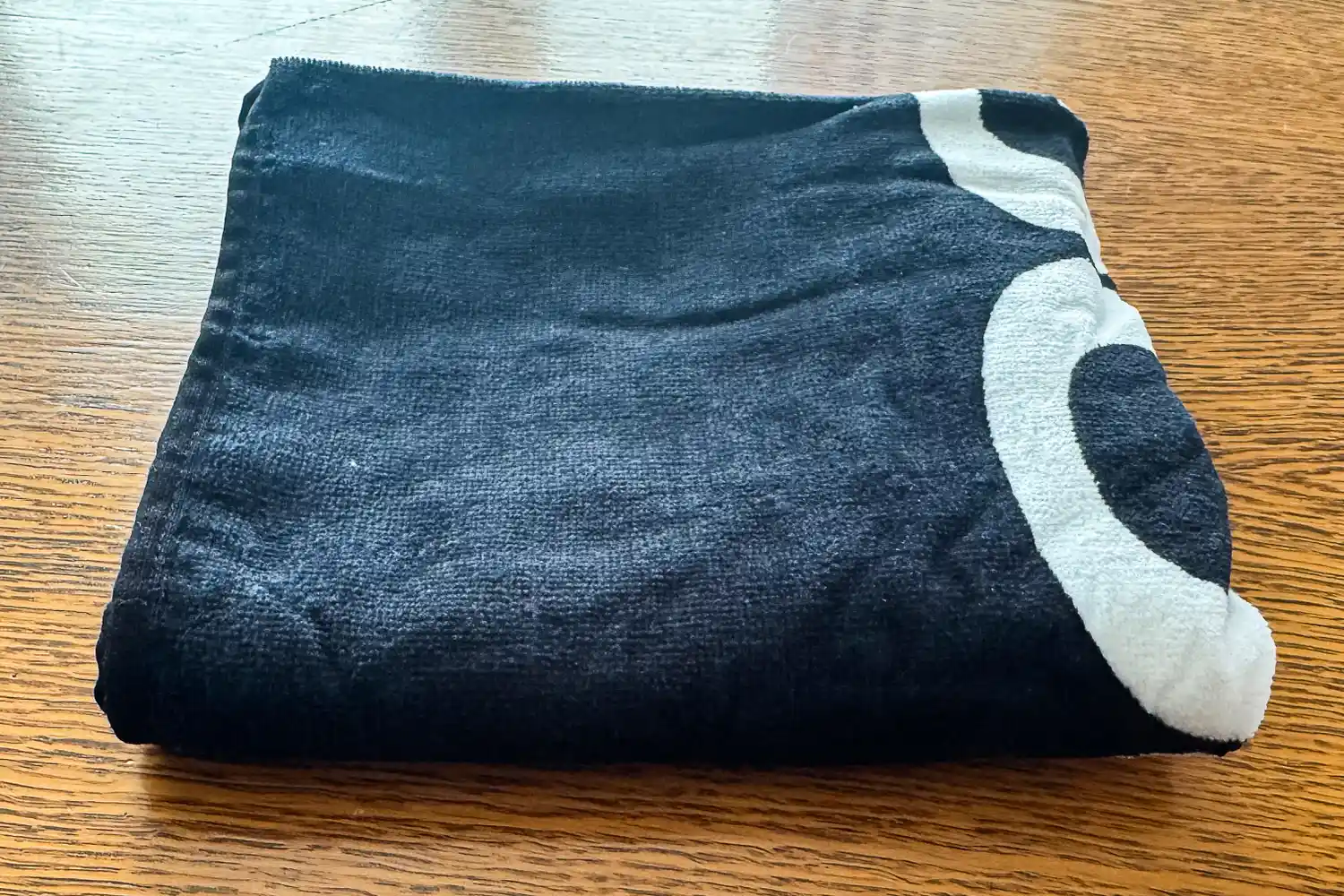 The Rogue Gym Towel is folded on a wooden table