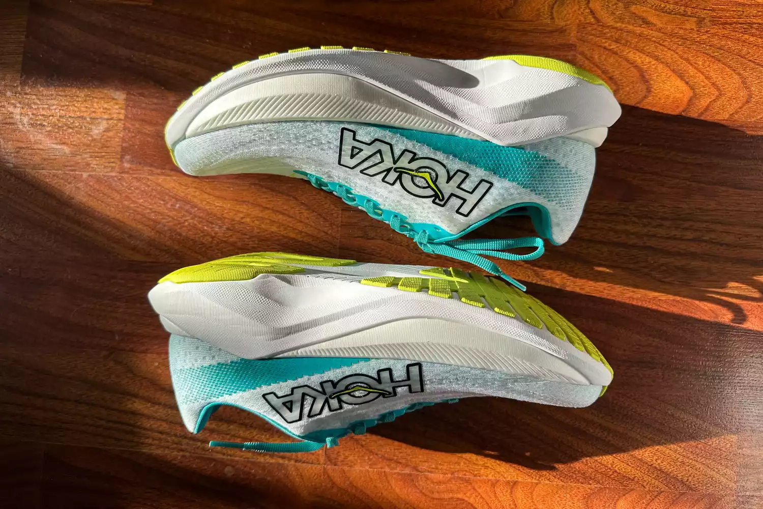 A pair of Hoka Mach X running shoes on a wood floor