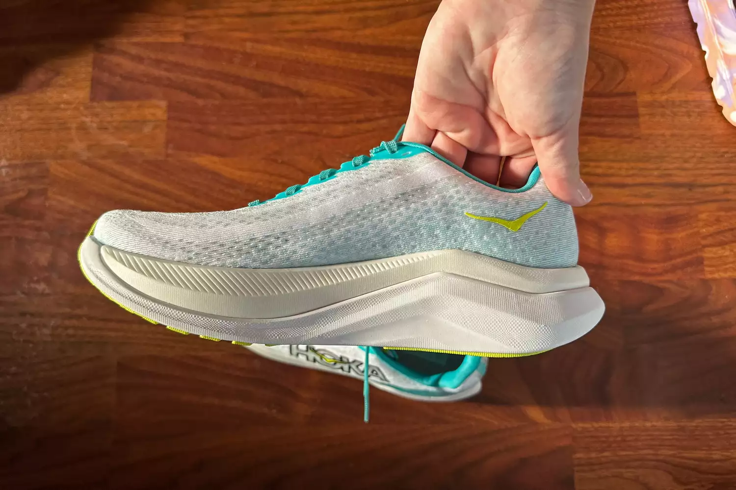 A person holding a Hoka Mach X running shoe