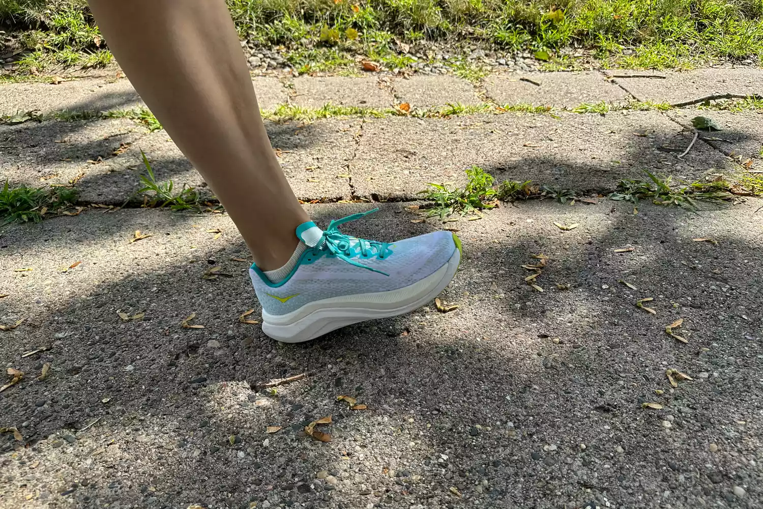 A person walking outside in Hoka Mach X running shoes