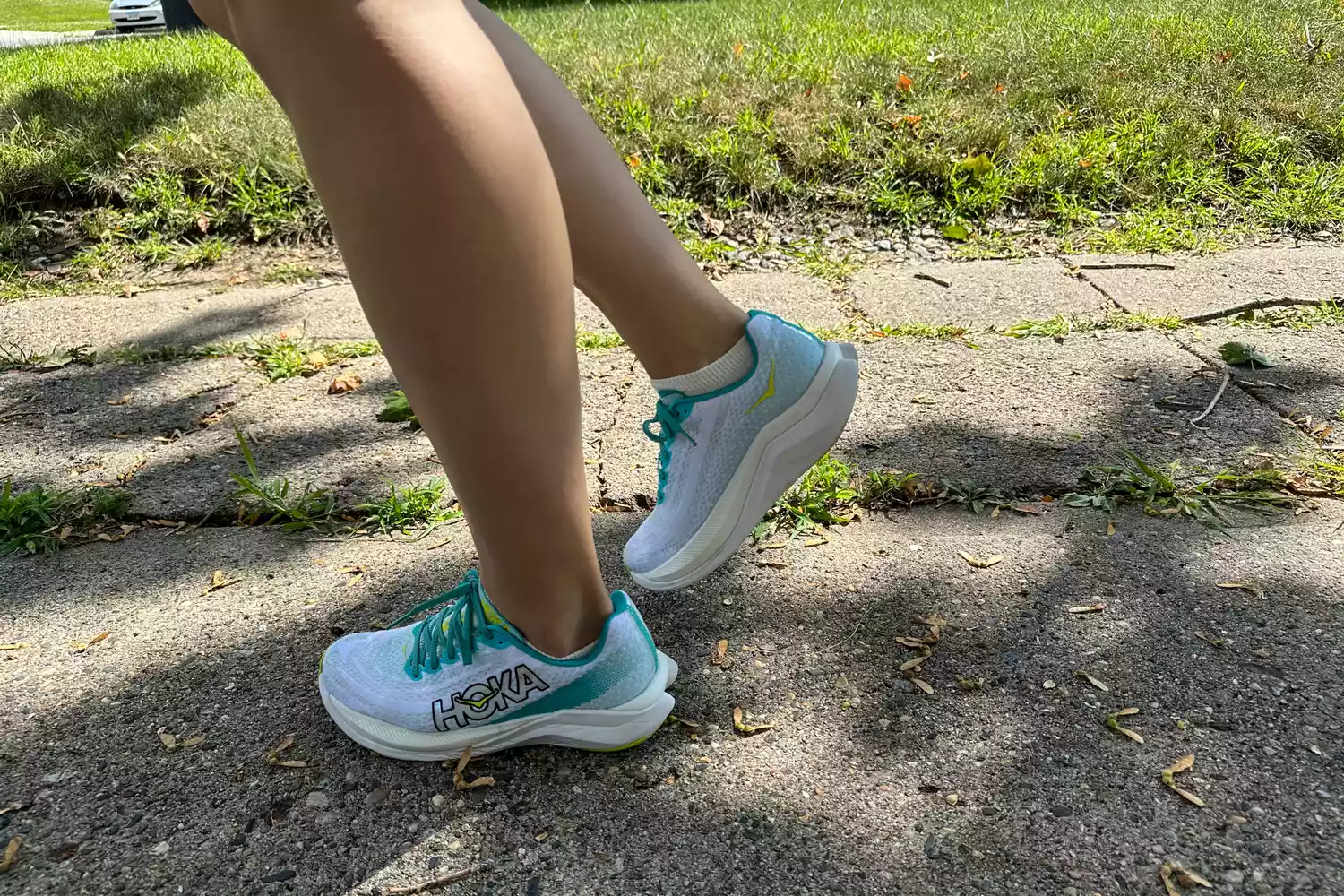 A person walking outside in Hoka Mach X running shoes