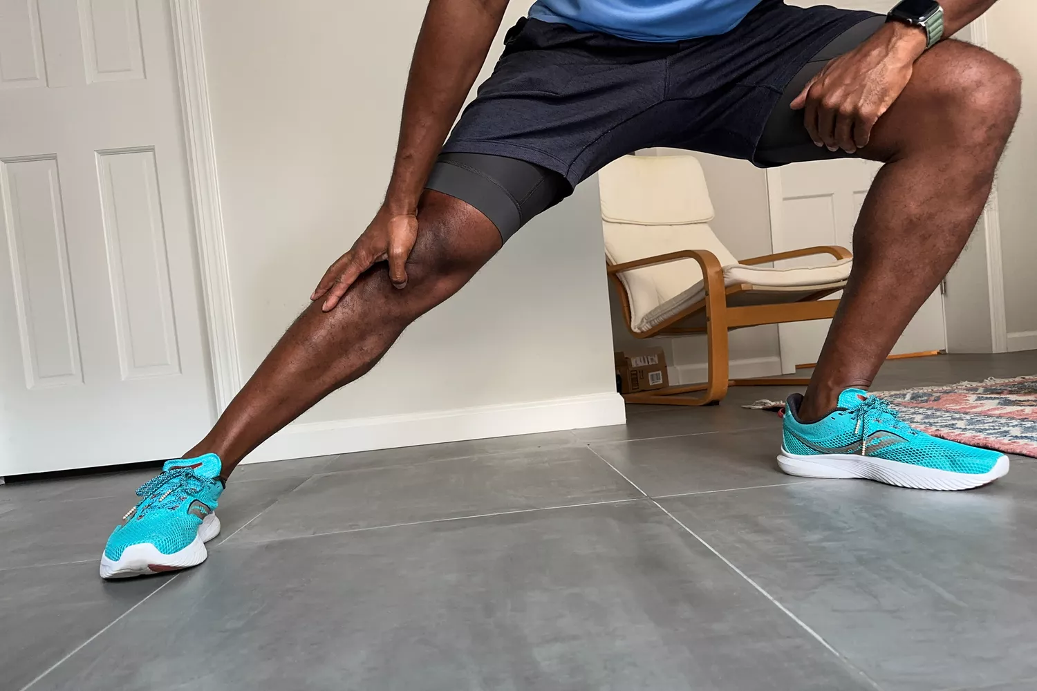 A person stretching while wearing the Saucony Men's Kinvara 14 Sneakers